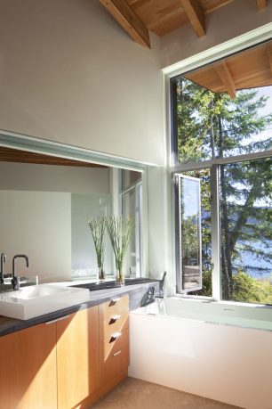 Bathroom with Aluminum Windows Overlooking the Lake Shuswap Cabin by Splyce Design