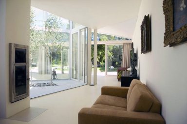Bright Sunroom with Brown Sofa and Glass Wall