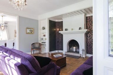 Warm Living Room with Purple Sofa and Fireplace Mantels