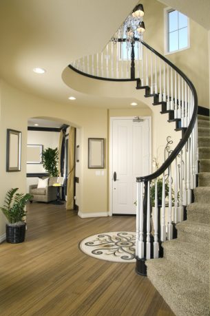 Modern entry way with wood floor and winding stairs
