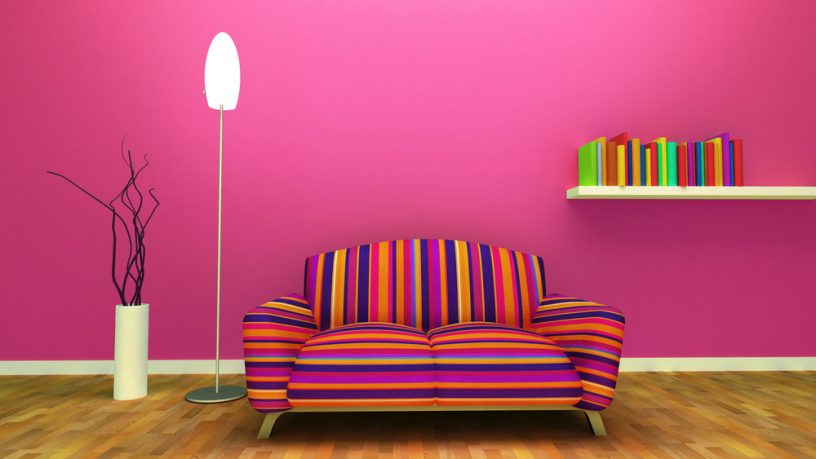 Pink wall room with multi color couch