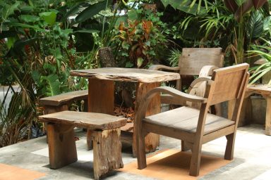 Wooden table and chairs in lush garden