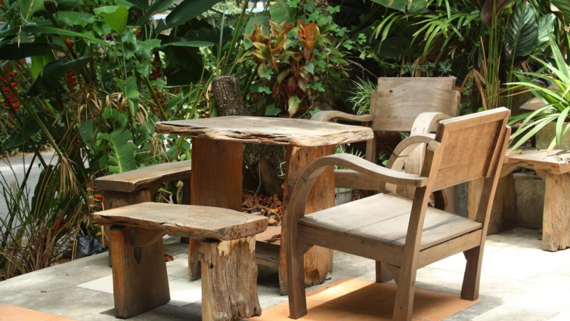 Wooden table and chairs in lush garden